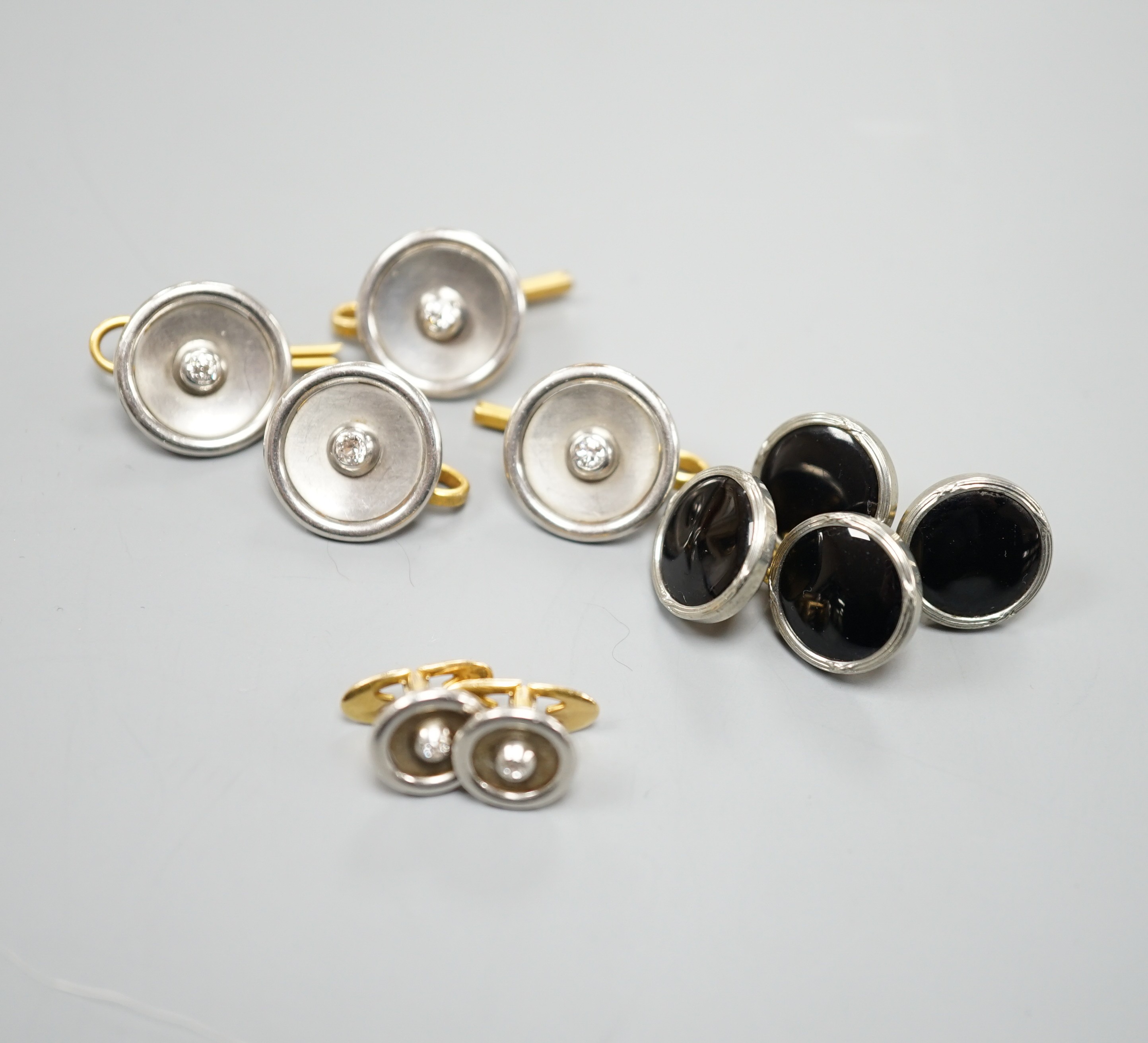 A pair of small pair of yellow and white metal diamond set cufflinks and four similar dress studs and four other yellow metal and black enamel? dress studs, gross weight 22.6 grams